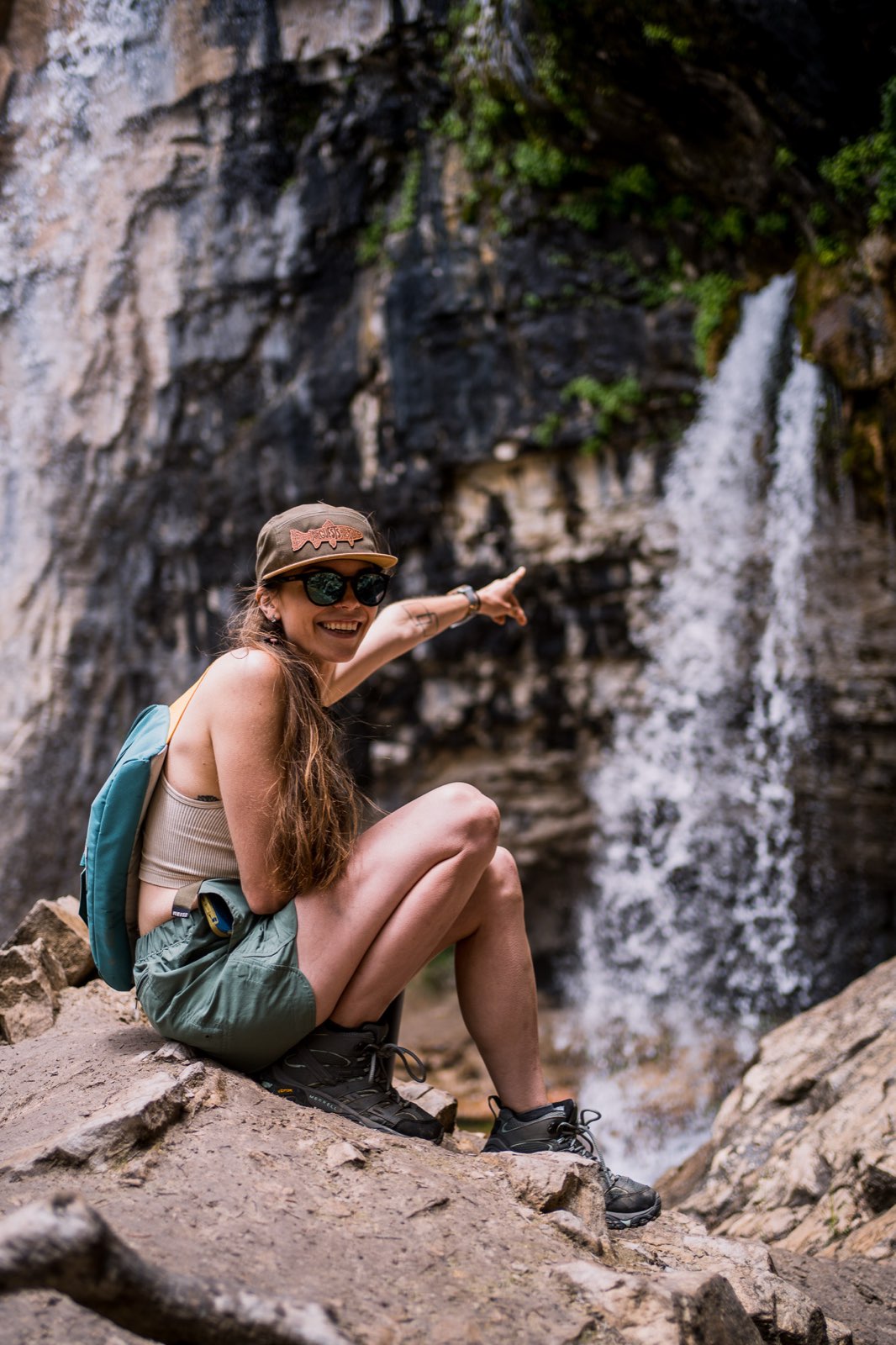 A hiker walking up a steep, exposed rocky trail with a loaded backpack.